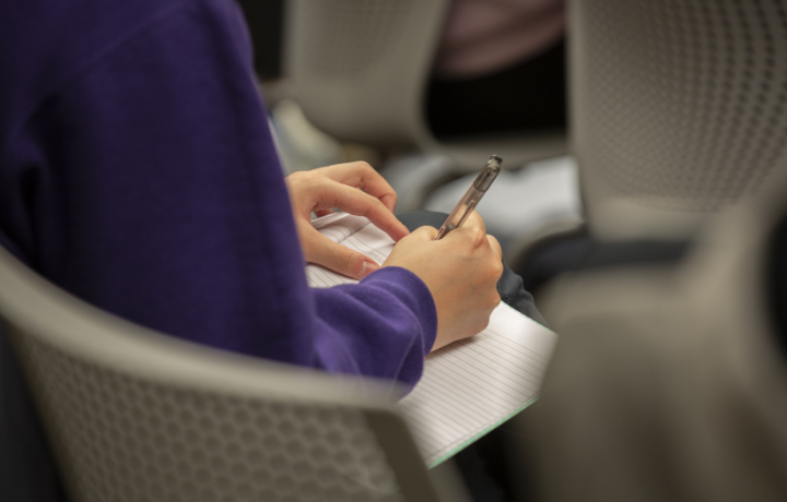 Close up of a human writing on a piece of paper