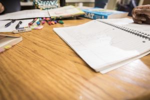 Desk covered in pens, pencils and notebooks