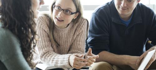 People talking together by a laptop