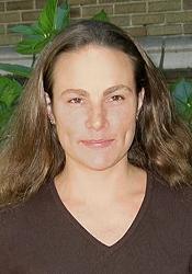 Headshot of smiling woman with brown hair and a brown shirt